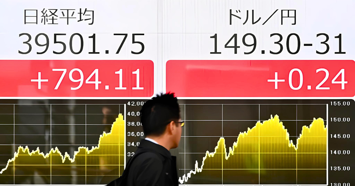 A man walks past a stock quotation board. 

Image Source: Arab News 